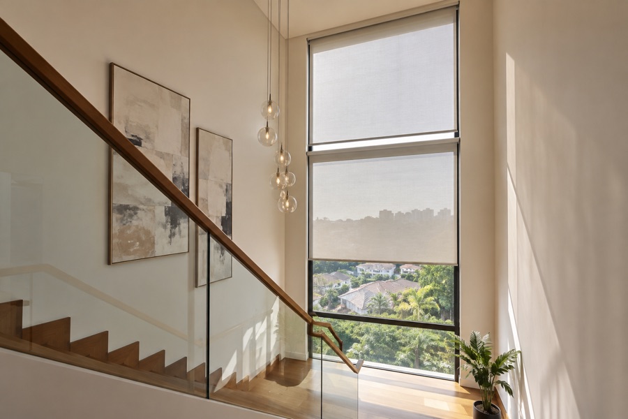 Motorised roller blinds fitted to a tall stairwell window
